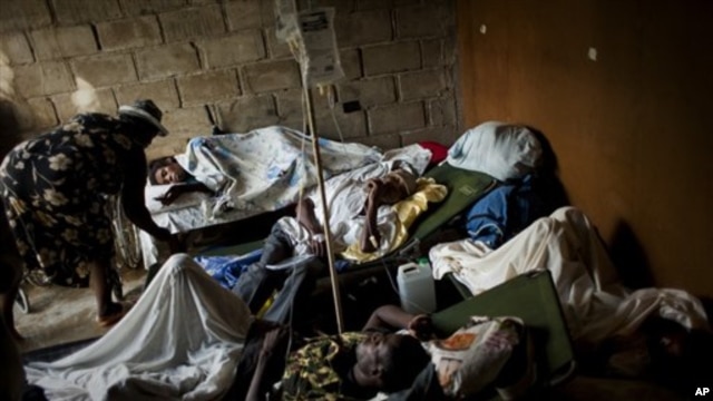 People suffering cholera symptoms rest on stretchers as they crowd the entrance of a public hospital in Limbe village near Cap-Haïtien, Haiti, 22 Nov 2010