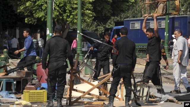 Egyptian riot police smash furniture and other items as they clear Tahrir Square in Cairo, September 15, 2012. 