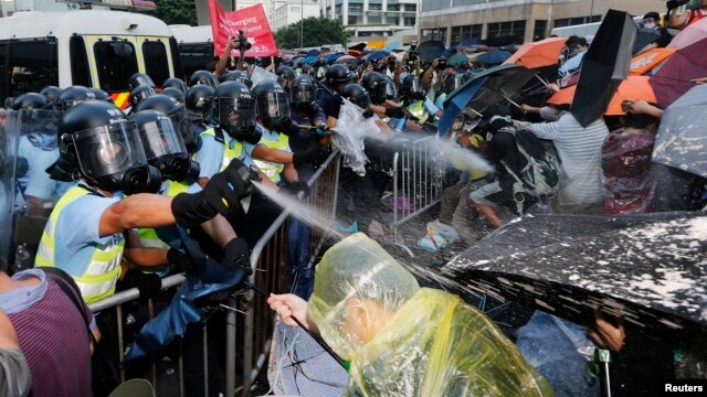 Cảnh sát chống bạo động xịt hơi cay trong lúc đụng độ với người biểu tình chặn con đường chính bên ngoài trụ sở chính quyền Hong Kong, ngày 28 tháng 9, 2014.