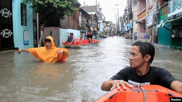 Residents wade through a flooded street during Tropical storm Fung-Wong in Pasay city, metro Manila, September 19, 2014.