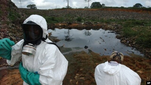 Waste removal experts work to extract hazardous black sludge from a garbage dump in Abidjan, Ivory Coast, September 17, 2006. (AP)