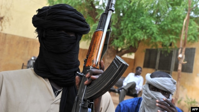 A picture taken on July 16, 2012 shows fighters of the Islamist group Movement for Oneness and Jihad in West Africa (MUJAO) sitting in the courtyard of the Islamist police station in Gao.