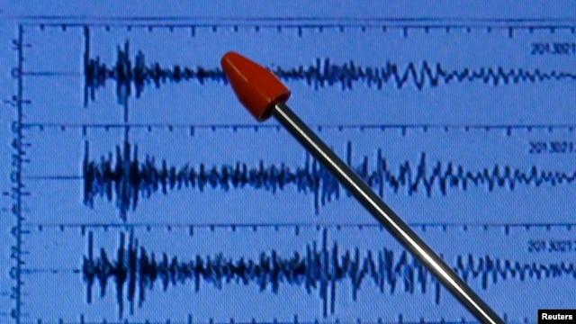 Official of Japan's earthquake agency points at graph of ground motion waveform data observed Feb. 12, 2013 from North Korean nuclear test