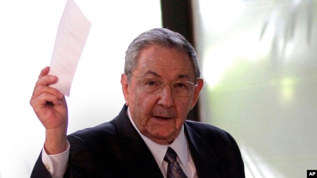 Cuba's President Raul Castro holds up the ballot of his brother Fidel, also present in the session,  for president of the National Assembly during the opening session of the parliament in Havana, Cuba, Feb. 24, 2012.  