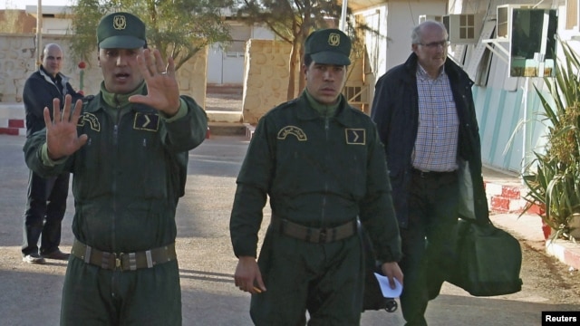 Tentara Aljazair mengawal seorang sandera Norwegia (kanan) yang berhasilnya meraka bebaskan dari penyanderaan oleh para militan (19/1). 