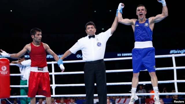 Pakistan's Muhammad Waseem (L) and Australia's Andrew Moloney react to the result of their boxing match at the 2014 Commonwealth Games in Glasgow, Scotland August 2, 2014. (REUTERS/Russell Cheyne)