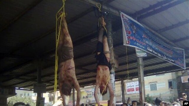 Egyptians surround the bodies of two men hung by their feet in a bus station after being accused of theft in the Nile Delta , about 90 kilometers north of Cairo, March 17, 2013. Egyptian vigilantes had beaten the two men, who they accused of stealing a motorized rickshaw, and who later died.