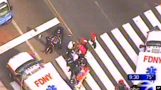  Pèsonèl sèvis dijans ap prese ale sou plas apre atak ki lakoz lanmò 2 moun e blese anpil lòt tou pre Empire State Building nan New York  vandredi 24 out  2012 la. (Foto WABC-TV)