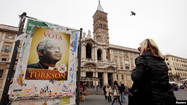 A woman looks at a poster supporting Cardinal Peter Turkson in front of the Papal Basilica of Saint Mary in Rome, March 1, 2013. 