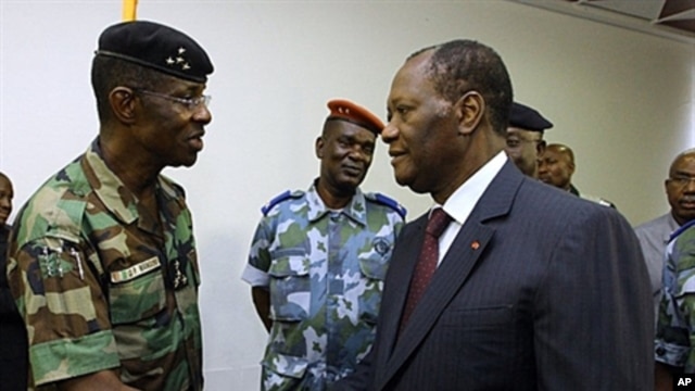 Ivory Coast's President Alassane Ouattara (R) shakes hands with General Philippe Mangou, chief of staff of former pro-Laurent Gbagbo Defense and Security Forces (FDS), at the Hotel du Golf in Abidjan, April 12, 2011