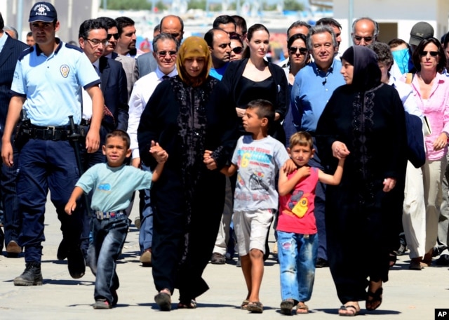Hollywood star Angelina Jolie, center left, in her role as special envoy for the U. N. refugee agency, and UNHCR chief Antonio Guterres, center right, at the Oncupinar Syrian refugee camp in Kilis, Turkey, September 13, 2012.