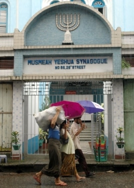 FILE - Residents walk past the Musmeah Yeshua Synagogue in downtown Rangoon, Oct. 2006.