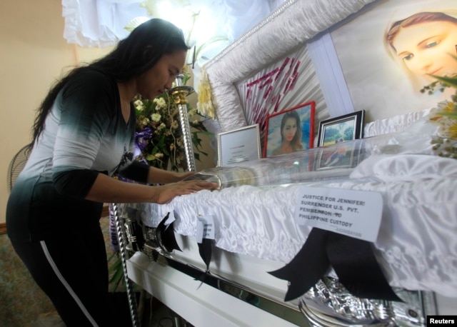 A woman pays her respects to slain transgender Jennifer Laude inside a funeral home in Olongapo city, north of Manila October 21, 2014. Philippine President Benigno Aquino rejected on Monday calls to tear up the Visiting Forces Agreement with the United S