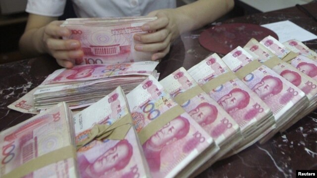 An employee counts Chinese 100 yuan banknotes at a branch of Bank of Communications in Shenyang, Liaoning province July 6, 2012.