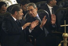 Mohamed Morsi, left, of Egypt's Muslim Brotherhood and Egyptian presidential hopeful Amr Moussa, right, at the Coptic cathedral in Cairo, January 6, 2012