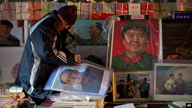 在中共领袖毛泽东冥诞120周年之际，一名旧书贩在北京某旧货市场摆放毛泽东画像。