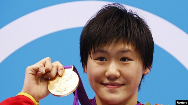 China's Ye Shiwen poses with her gold medal on the podium during the women's 400m individual medley victory ceremony at the London 2012 Olympic Games at the Aquatics Centre July 28, 2012.