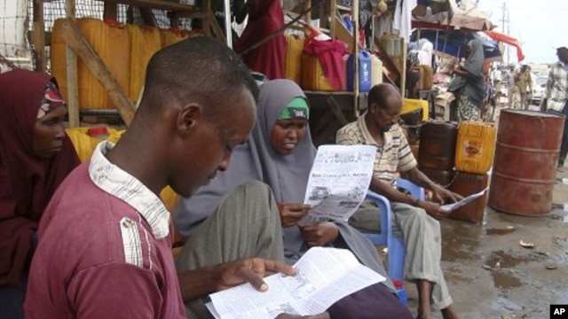 People read local newspapers reporting the death of al-Qaida leader Osama bin Laden, in the streets of Somalia's capital Mogadishu, May 3, 2011
