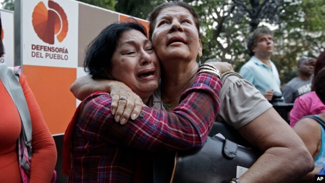 Supporters of Venezuela's President Hugo Chavez weep as she learn that Chavez has died through an announcement by the vice president in Caracas, Venezuela, Tuesday, Mar. 5, 2013.