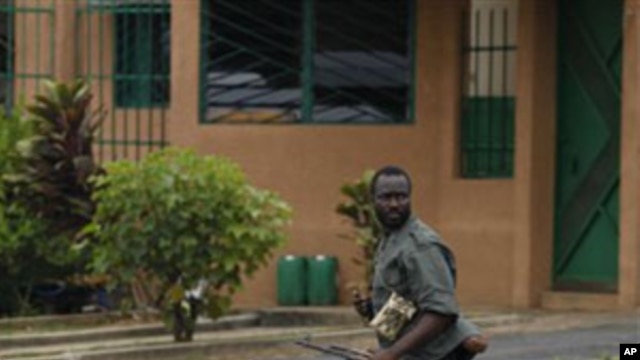 A Republican Forces soldier runs as security forces loyal to President Alassane Ouattara investigate reports of looting, in the Cocody neighborhood of Abidjan, Ivory Coast,  April 13, 2011