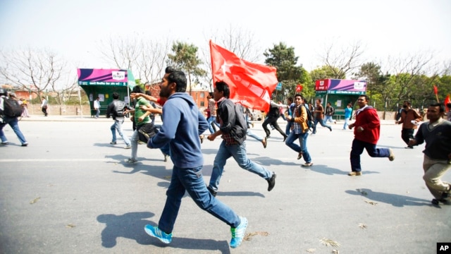 Members of a splinter faction of the Unified Communist Party of Nepal Maoist run and shout slogans as they protest against the formation of an interim government in Katmandu, Nepal, March 14, 2013.