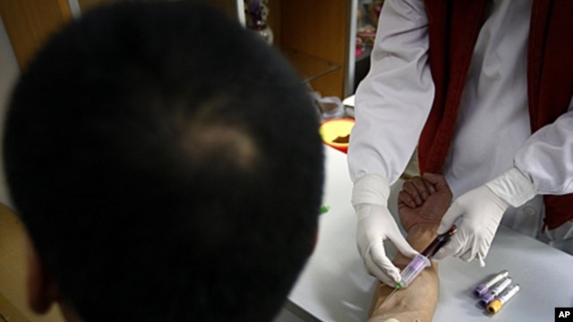A man has a sample of blood taken by a nurse for testing at the HIV/AIDS ward of Beijing YouAn Hospital. The number of new HIV/AIDS cases in China is soaring, with rates of infections among college students and older men rising. The Chinese Center for Dis