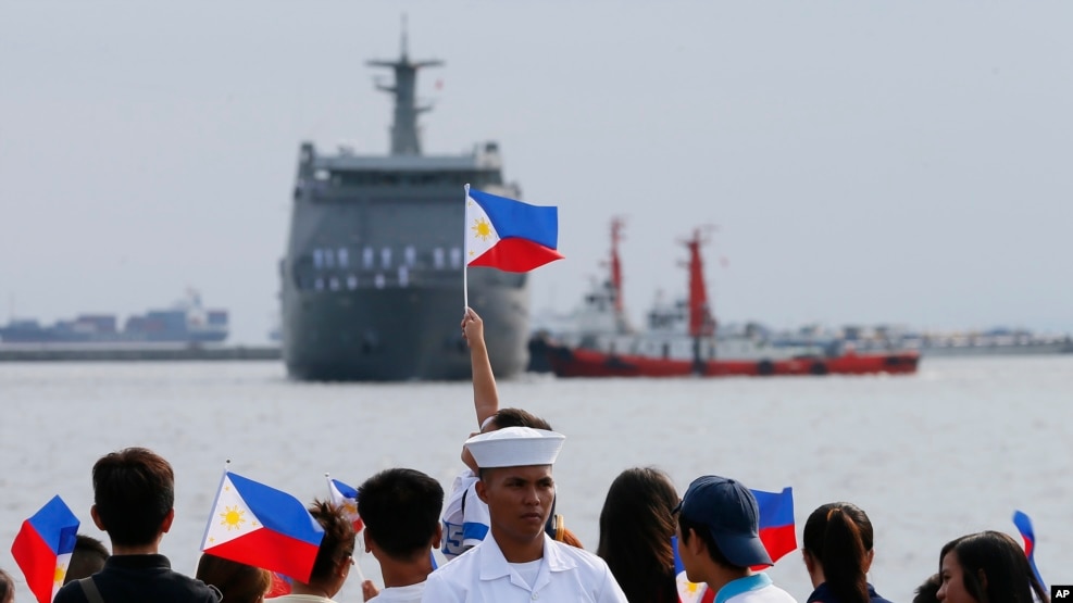 FILE - Relatives of crew of BRP Tarlac of the Philippine Navy wave Philippine flags to welcome its arrival at the South Harbor in Manila, Philippines, May 16, 2016. The radars Manila is purchasing from the U.S. will be mounted on Navy ships.