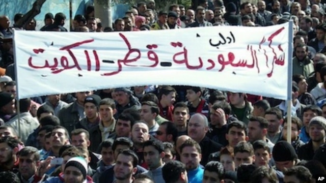In this Friday, March 2, 2012 citizen journalism image provided by the Local Coordination Committees in Syria, anti-Syrian regime protesters hold up a banner in Arabic reading: "thank you Saudi Arabia, Qatar and Kuwait," during a demonstration, in Idlib, 