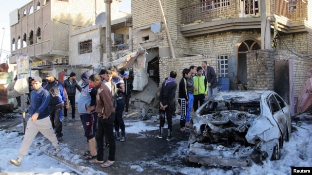 Residents gather at the site of a car bomb attack in the Hurriya district in Baghdad, January 10, 2013.