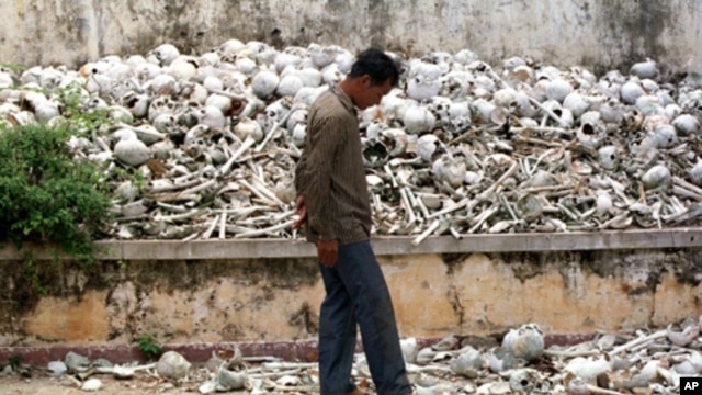A Cambodian man walks past one of the many killing fields sites at a school on the outskirts of Phnom Penh.