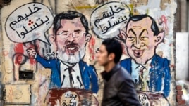 A protester walks past a graffiti during a march at Tahrir Square in Cairo, February 11, 2013. The march, was organized by Egyptians who oppose Egypt's President Mohamed Morsi and members of the ruling Muslim Brotherhood on the second anniversary of the r