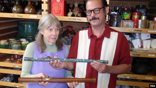 Donor Steven Martin and University of Idaho curator Priscilla Wegars hold antique opium pipes. (VOA/T. Banse)      