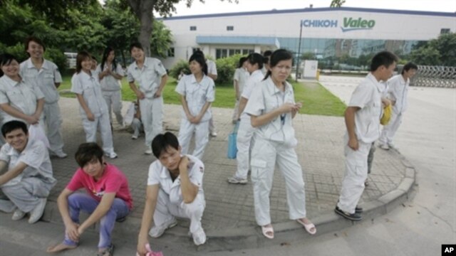 Chinese workers stand outside the Ichikoh Valeo factory, a Japanese-owned plant that makes head lamps and fog lights for the auto industry, in Foshan, southern China's Guangdong province, 18 Jun 2010