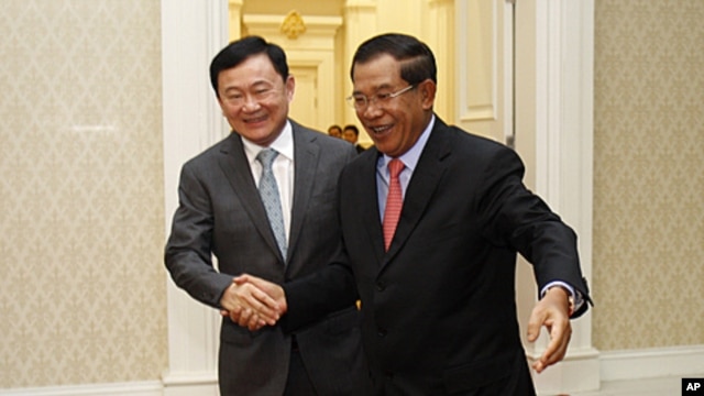 Former Thai Prime Minister Thaksin Shinawatra, left, is welcomed by Cambodian Prime Minister Hun Sen upon arrival at Peace Palace in Phnom Penh, Cambodia, September 17, 2011.