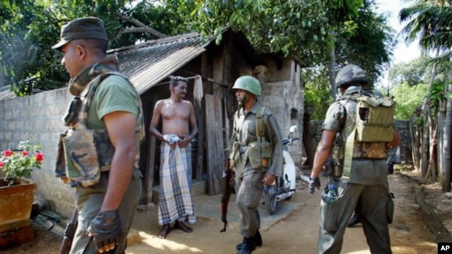 Seorang warga Tamil mengamati anggota tentara Sri Lanka yang sedang menggelar operasi pencarian di Jaffna pasca perang saudara di wilayah itu (Foto: dok). Partai utama suku Tamil mendesak PBB agar menebus kegagalan yang telah diakuinya dalam upaya melindungi warga sipil Tamil dengan memulai penyelidikan internasional (16/11).