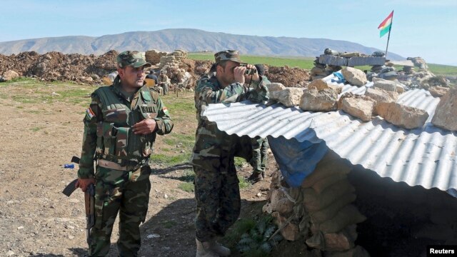 Members of the Kurdish Peshmerga forces stand guard at a security point on Bashiqa mountain, overlooking Islamic State held territories of Mosul, 12 kilometers northeast of Mosul City, March 7, 2015.