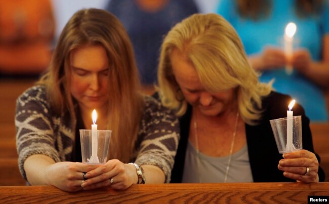 Laura Goodman y su madre Peggy Harrison sostienen velas en una vigilia de oración por las víctimas de un tiroteo el viernes en Virginia Beach, Virginia, EE.UU., 1 de junio de 2019.