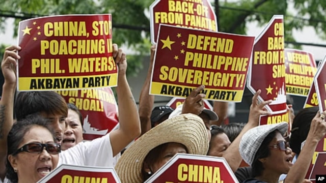Protesters display placards during their rally outside the Chinese Consulate at the financial district of Makati city, east of Manila, Philippines, April 16, 2012.