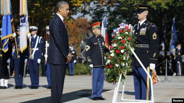 President Barack Obama (L) is seen after placing a Veterans Day wreath at the Tomb of the Unknowns at Arlington National Cemetery in Arlington, Virginia, November 11, 2012.  