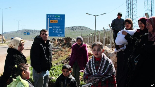 Syrian refugees gather up before a walk outside their camp in Reyhanli, Turkey, Sunday, March 4, 2012. 