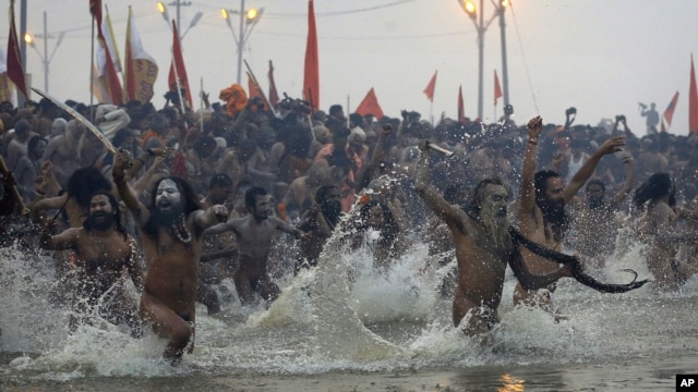 Indian Hindu holy men run naked into the water at Sangam, the confluence of the rivers Ganges, Yamuna and mythical Saraswati, during the royal bath at the start of the Kumbh Mela in Allahabad, India, Janaury 14, 2013.