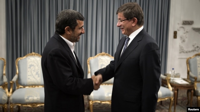 Turkey's Foreign Minister Ahmet Davutoglu (R) shakes hands with Iranian President Mahmoud Ahmadinejad before an official meeting in Tehran, January 5, 2012. 