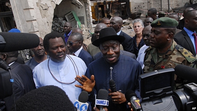 Nigerian President Goodluck Jonathan (C) and "ThisDay" newspaper owner Nduka Obaigbena (L) visit the site of an April 26 suicide attack which struck the newspaper's offices, in Abuja, on April 28, 2012.