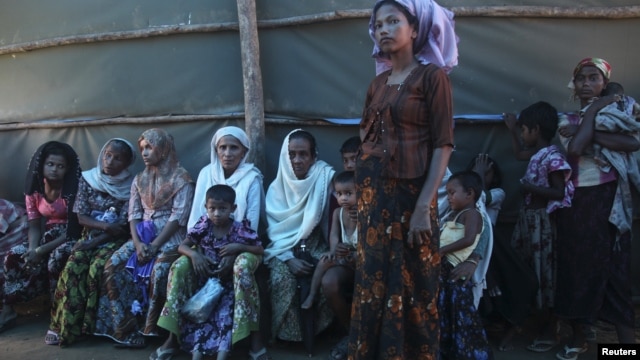 Shofica Belcom, 25, waits with other mothers at a Burma Red Cross health clinic near Sittwe, capital of Burma's Rakhine state, October 14, 2012. 