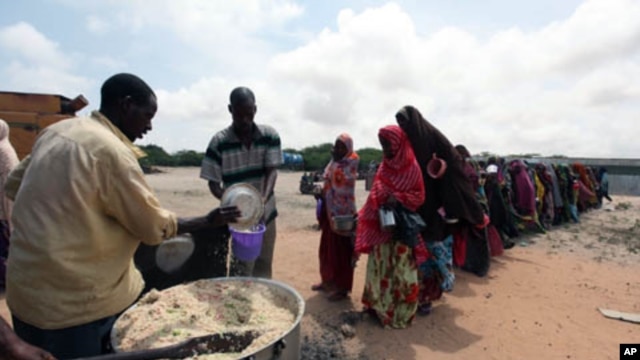 Internally displaced Somali people stand in line as they wait for cooked food in Hodan district, south of capital, Mogadishu, September 5, 2011.