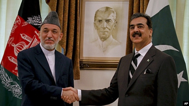 Afghan President Hamid Karzai, left, shakes hand with Pakistani Prime Minister Yousuf Raza Gilani prior to their meeting in Islamabad, Pakistan on Saturday, June 11, 2011
