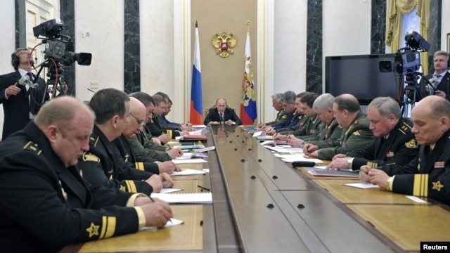 Russian President Vladimir Putin (C) attends a meeting with defence ministry officials in Moscow, May 30, 2012.