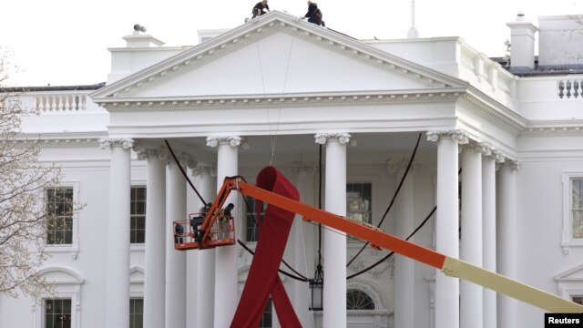 A large red ribbon is installed on the North Portico of the White House to mark World AIDS Day on December 1, in Washington, D.C., November 30, 2012.