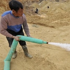 A Chinese worker waters the site of a rare earth metals mine at Nancheng county, Jiangxi province, December 29, 2010.