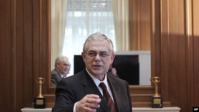Greek Prime Minister Lucas Papademos welcomes members of Hellenic Confederation of Professionals, Craftsmen and Merchants during a meeting in Athens, January 4, 2012.